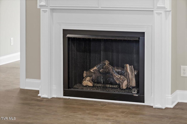 room details with a fireplace, baseboards, and wood finished floors