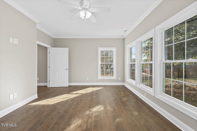 spare room with dark wood-style flooring, crown molding, baseboards, and ceiling fan