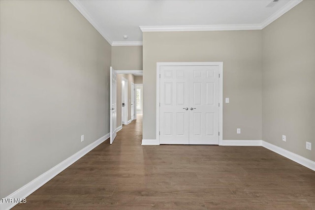 unfurnished bedroom with dark wood-style floors, baseboards, ornamental molding, and a closet