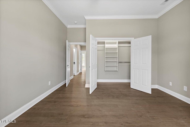 unfurnished bedroom featuring baseboards, a closet, dark wood finished floors, and crown molding