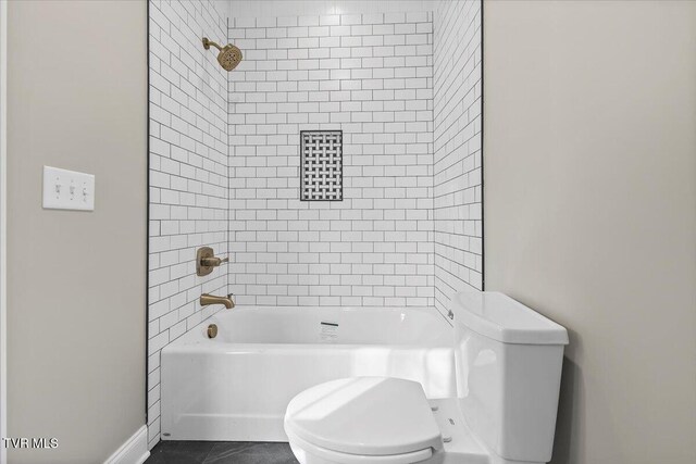 full bath featuring tile patterned flooring, bathing tub / shower combination, and toilet