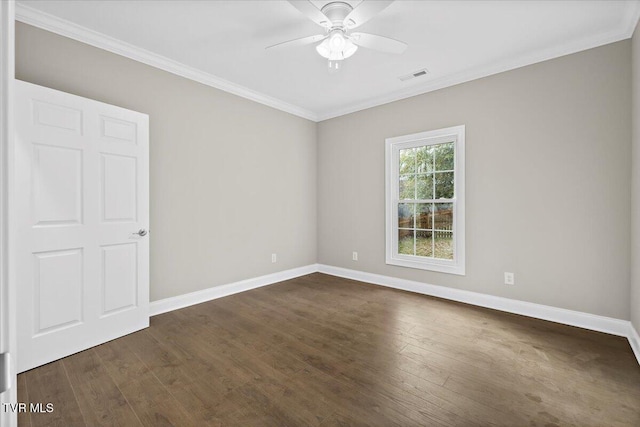 empty room with baseboards, visible vents, dark wood finished floors, ceiling fan, and crown molding