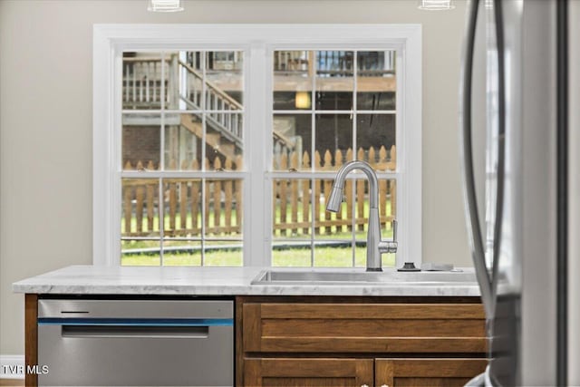 bar with stainless steel appliances, a healthy amount of sunlight, and a sink