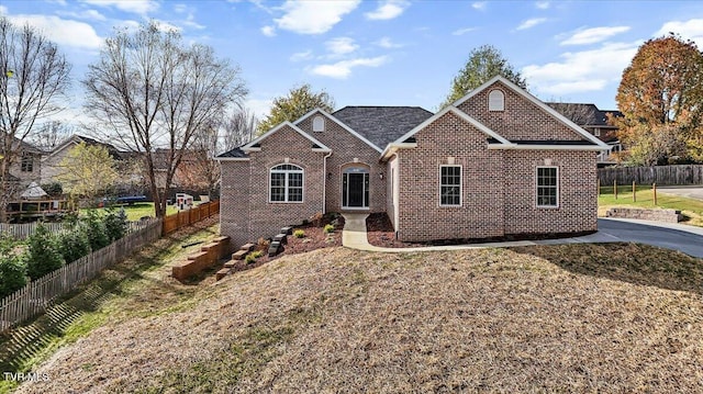 ranch-style house featuring fence and brick siding