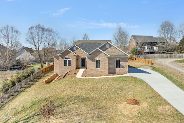 view of front of house with a residential view, fence, a front lawn, and brick siding