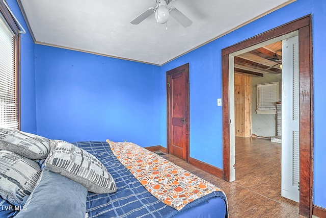 bedroom featuring ceiling fan, crown molding, and wood walls