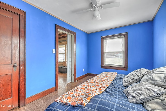 bedroom with hardwood / wood-style flooring, ceiling fan, and crown molding