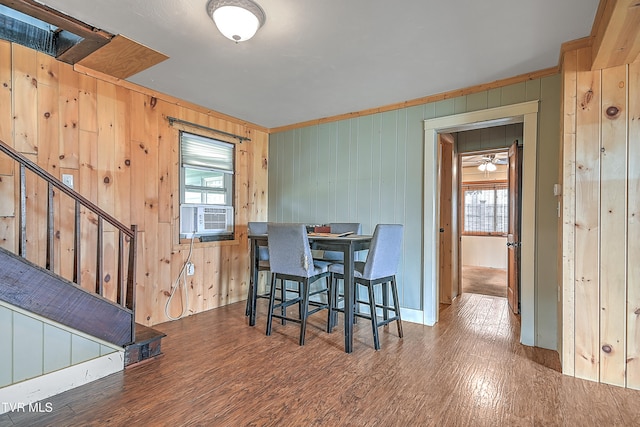 dining room featuring wooden walls, cooling unit, dark hardwood / wood-style floors, and plenty of natural light