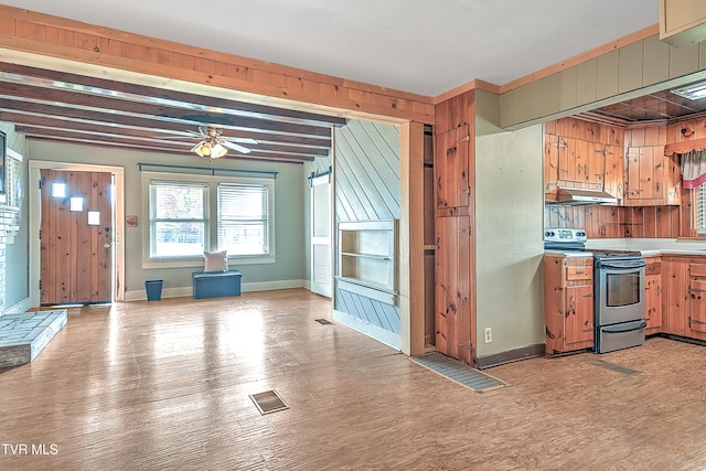 kitchen featuring light hardwood / wood-style floors, ceiling fan, stainless steel electric range, beam ceiling, and ventilation hood