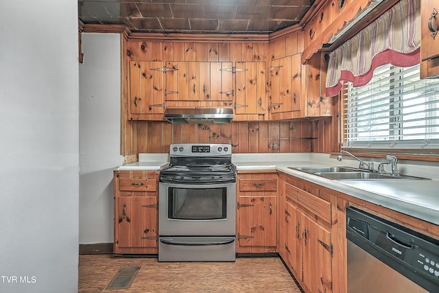 kitchen featuring sink, light hardwood / wood-style floors, stainless steel appliances, and range hood