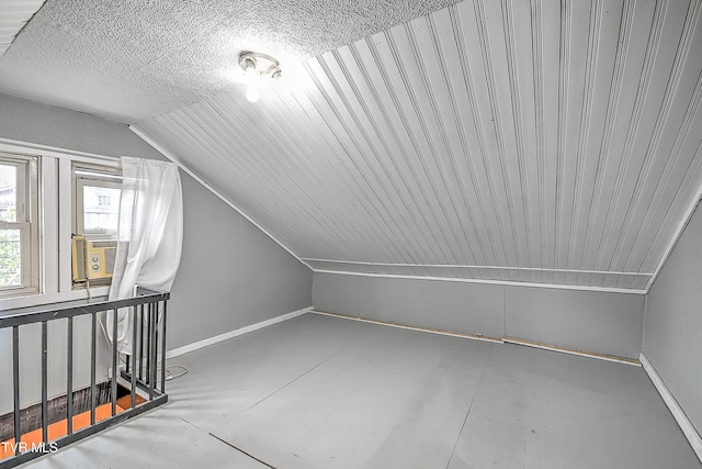 additional living space with lofted ceiling, concrete flooring, and cooling unit