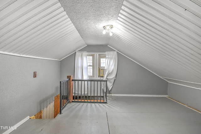 additional living space featuring lofted ceiling and a textured ceiling