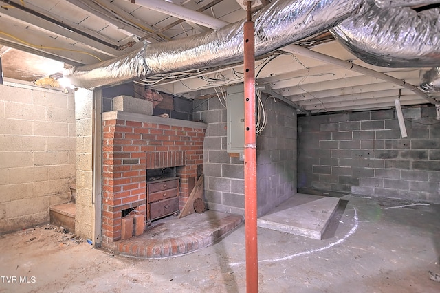 basement featuring electric panel and a brick fireplace