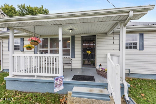 view of exterior entry featuring covered porch