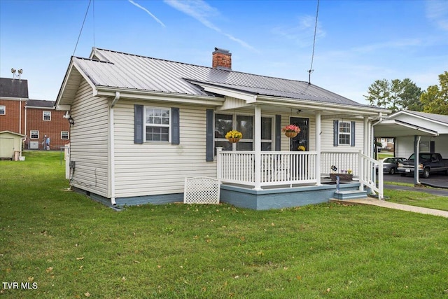 view of front of home with covered porch, a front yard, and a carport