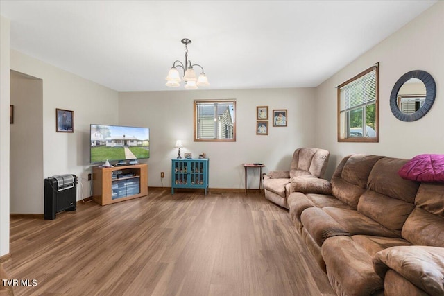 living room featuring wood-type flooring and an inviting chandelier