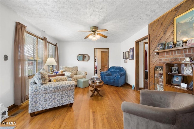 living room featuring hardwood / wood-style floors, a textured ceiling, and ceiling fan