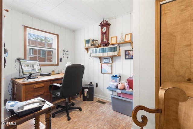 office space featuring light hardwood / wood-style floors and wood walls