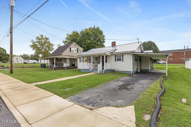 1312 Happy Valley St, Elizabethton, TN 37643 - farmhouse with metal roof, a front lawn, a porch, and driveway