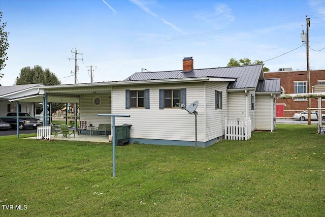 back of house featuring a patio area and a yard