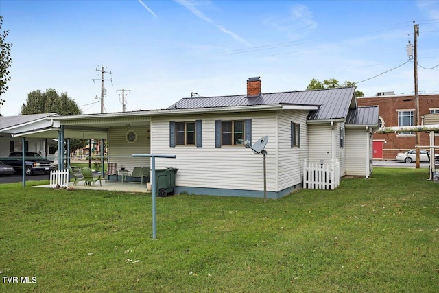 1312 Happy Valley St, Elizabethton, TN 37643 - back of house with a lawn, a carport, a chimney, and metal roof