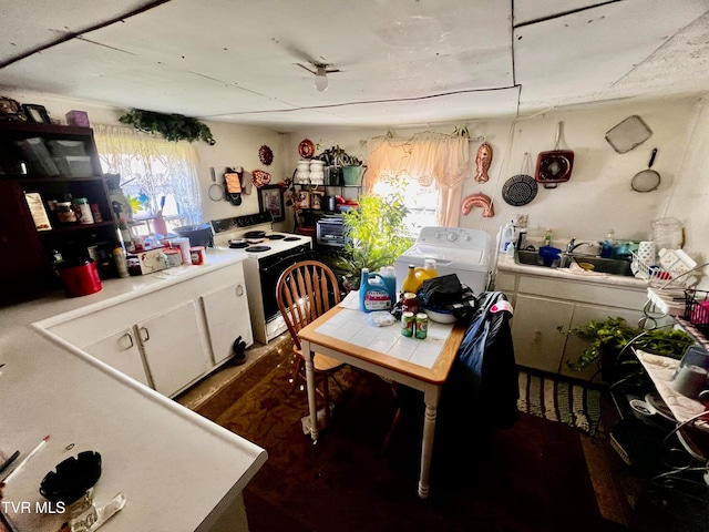 kitchen with washer / dryer, white electric range oven, and white cabinets