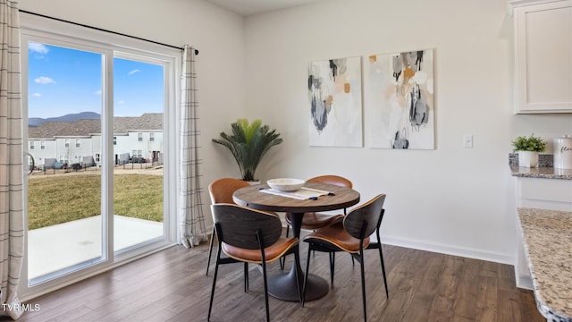 dining area with dark wood-style floors, a healthy amount of sunlight, and baseboards