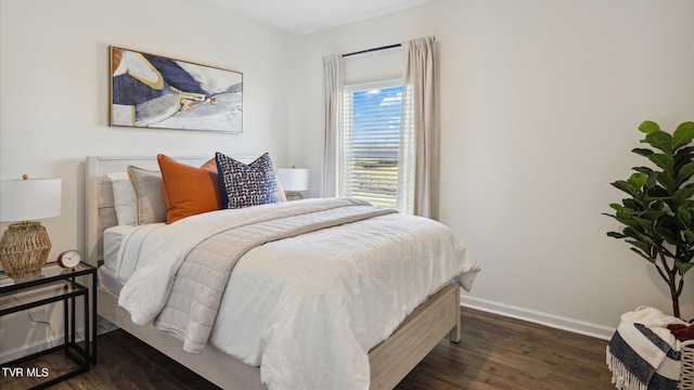 bedroom with dark wood-type flooring and baseboards