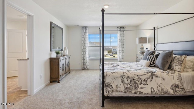 bedroom with baseboards and light colored carpet