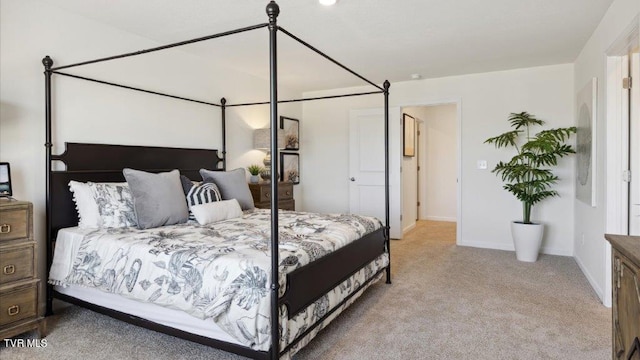 bedroom with light carpet and baseboards