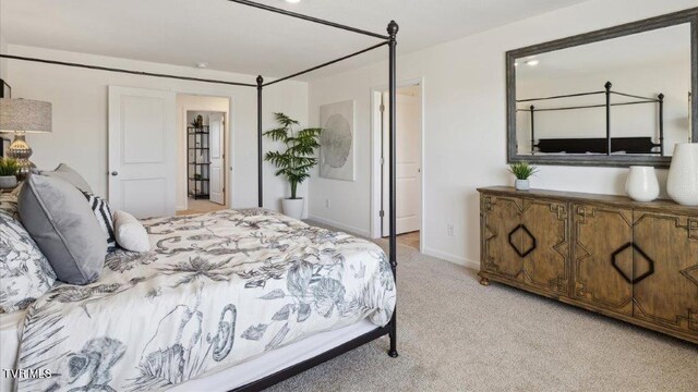 bedroom featuring light carpet and baseboards