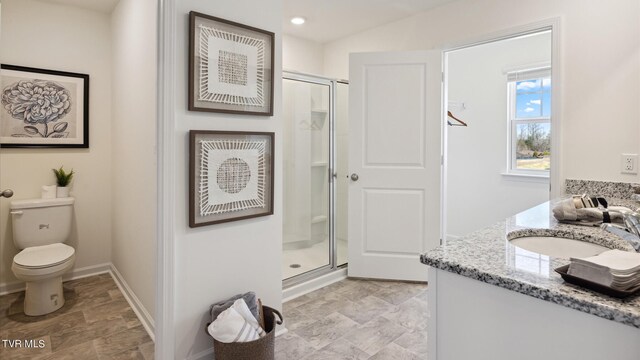 bathroom featuring toilet, recessed lighting, vanity, baseboards, and a stall shower