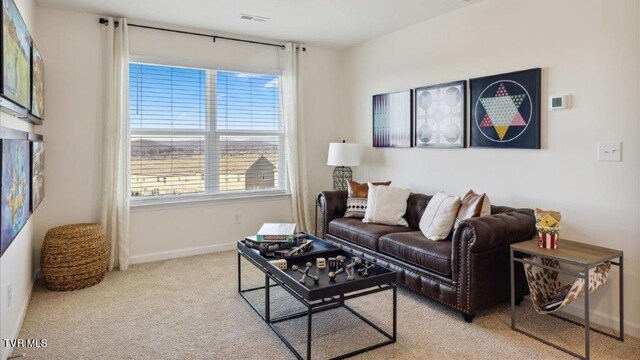 carpeted living area featuring visible vents and baseboards