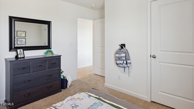 bedroom with light carpet and baseboards