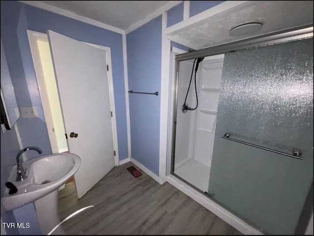 bathroom with crown molding, walk in shower, and hardwood / wood-style flooring