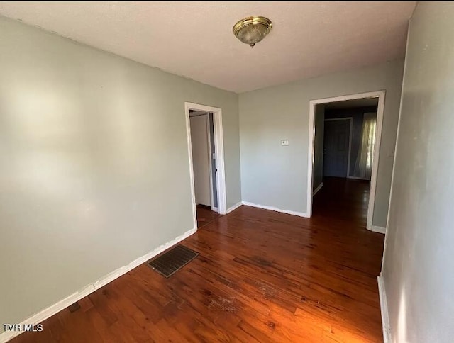 unfurnished room with dark hardwood / wood-style floors