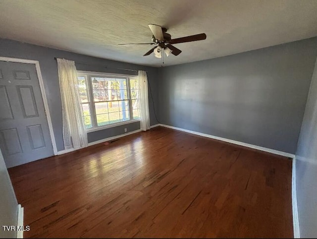 spare room featuring ceiling fan and dark hardwood / wood-style flooring