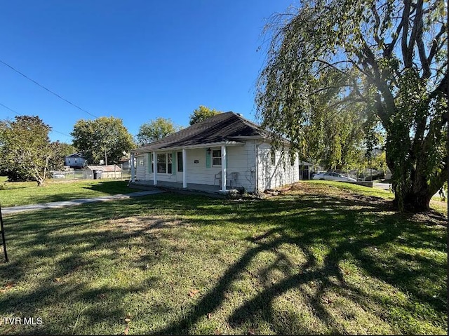 view of side of home with a yard