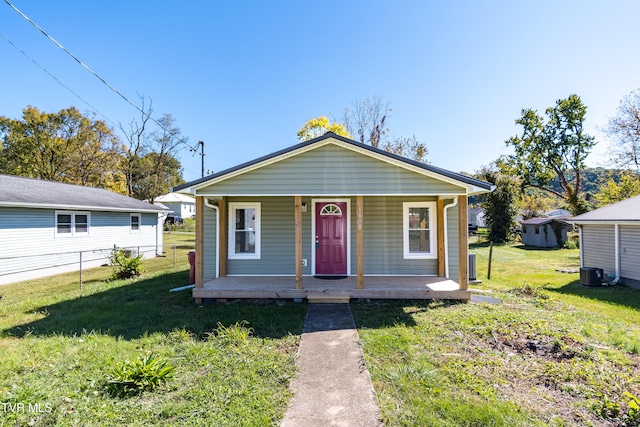 bungalow featuring a storage shed, central AC, a porch, and a front lawn