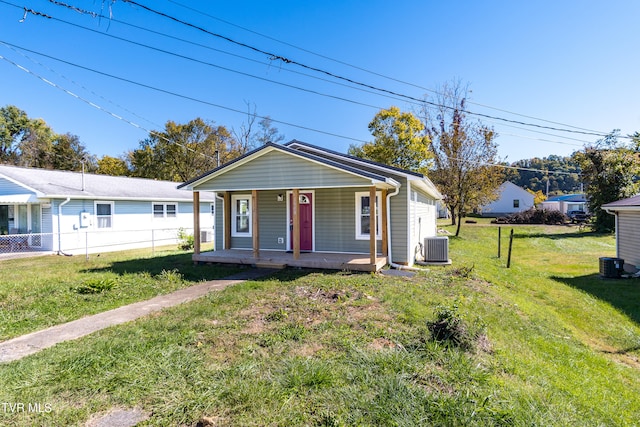 bungalow-style home featuring a front yard, a porch, and central AC unit