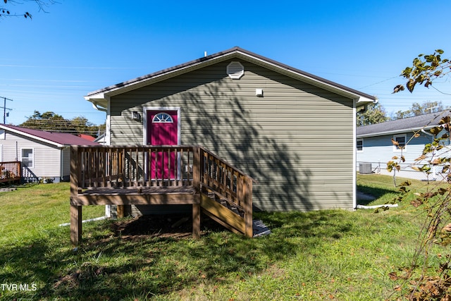 back of property with a deck and a yard