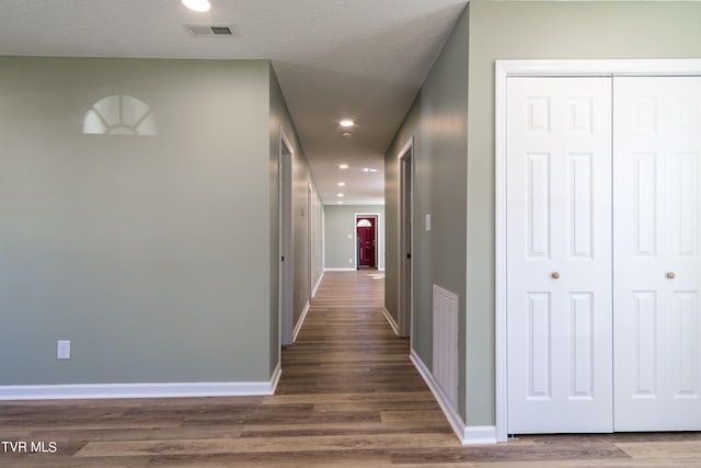 corridor featuring dark hardwood / wood-style floors and a textured ceiling