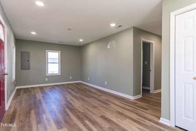 empty room with dark wood-type flooring and electric panel