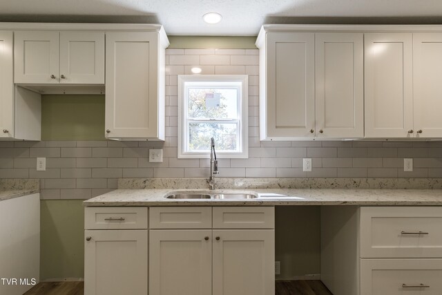 kitchen with sink, white cabinetry, backsplash, and dark hardwood / wood-style flooring