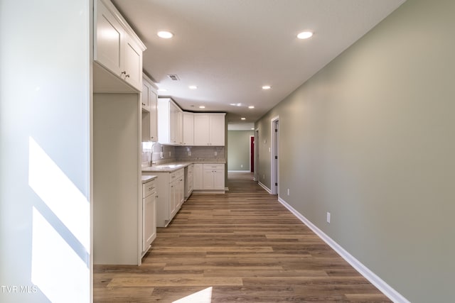 kitchen with white cabinets, sink, backsplash, and dark hardwood / wood-style flooring