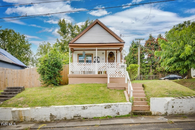 bungalow-style home with a front yard and covered porch