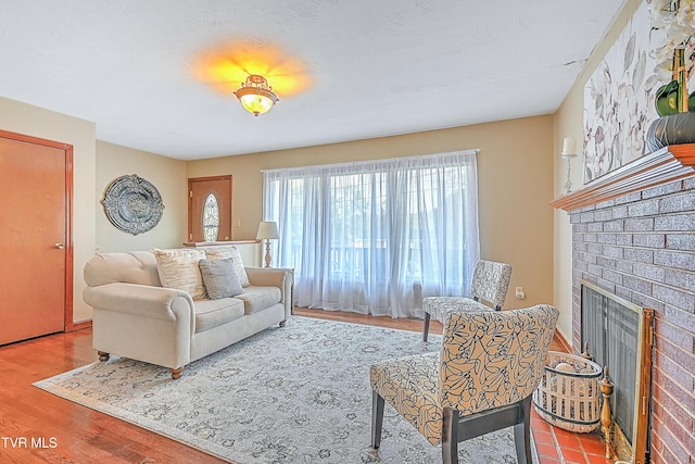 living area with wood finished floors and a brick fireplace