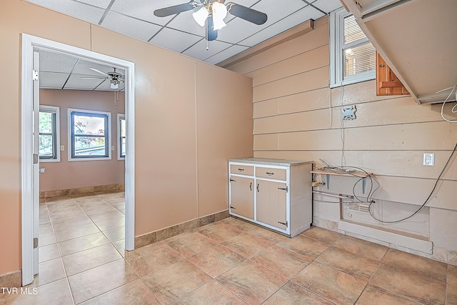 interior space with wooden walls and ceiling fan