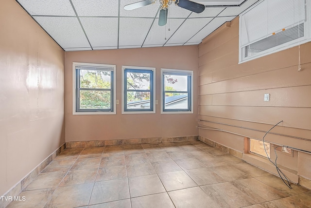 empty room featuring plenty of natural light, baseboards, and ceiling fan