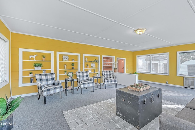 living room featuring carpet floors, built in features, baseboards, and heating unit